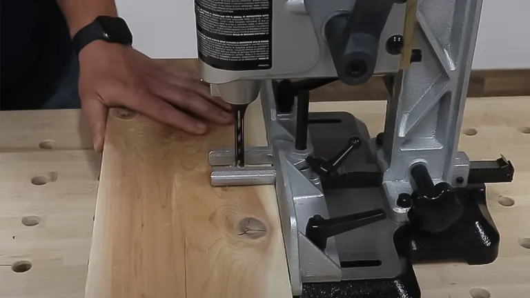 Person using a Delta 1/2 HP Benchtop Mortising Machine on a wooden plank