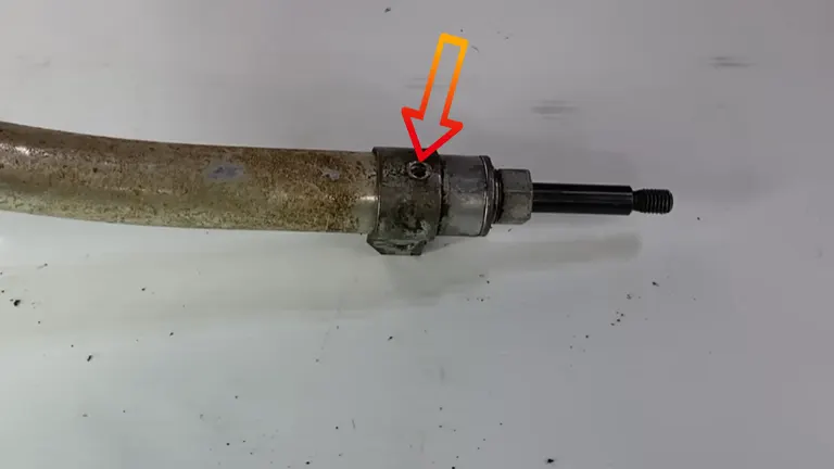 Trimmer shaft showing the hidden greasing point with an arrow