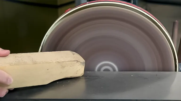 A piece of wood being sanded on a spinning Grizzly G0702 - 12" Disc Sander with Brake