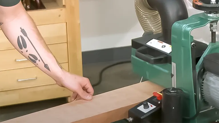 Person using the Grizzly G0716 10-inch 1 HP Drum Sander in a woodworking workshop