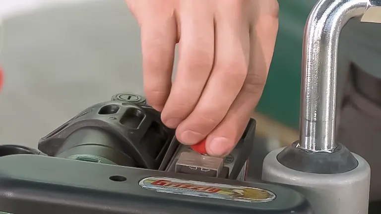 Close-up of a hand operating a Grizzly power feeder switch