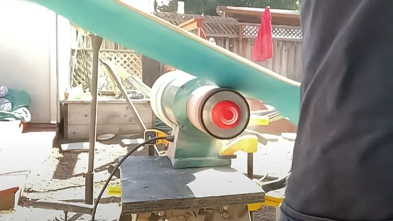 In-action view of a Grizzly G8749 Drum Sander with red end caps, on an outdoor workbench