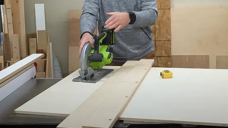 Using a circular saw and guide to cut plywood on a workbench