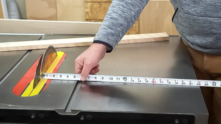 Person measuring on a table saw for plywood cutting