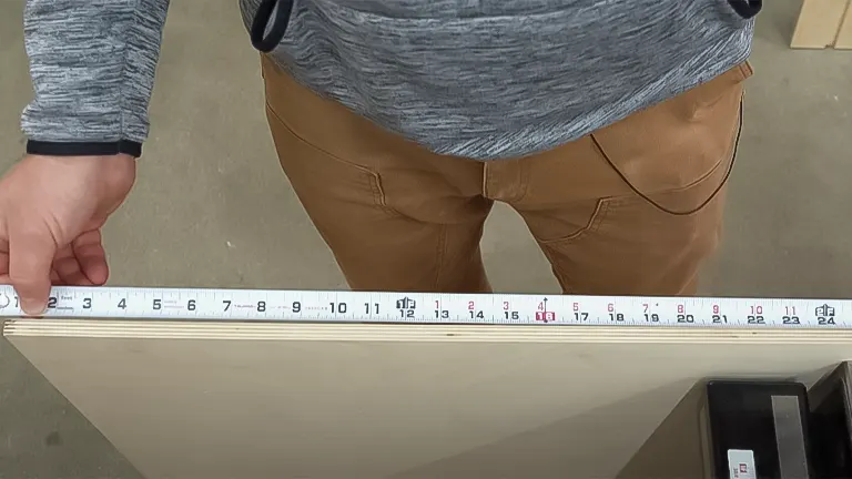 Person measuring plywood edge with tape measure