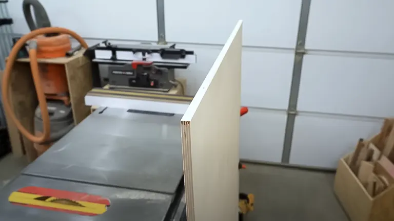 Edge of plywood standing vertically on a table saw surface