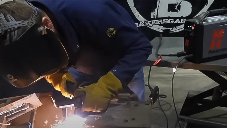 Worker cutting metal with a Hypertherm Powermax45 XP plasma cutter