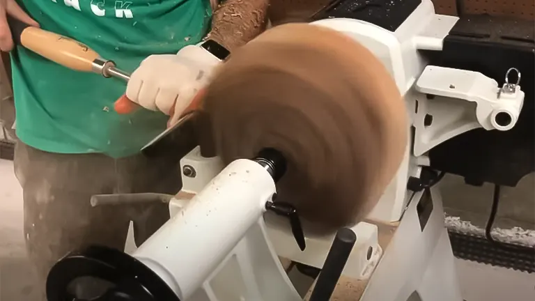 Person carving a wooden piece on a JET JWL-1640EVS lathe with a chisel
