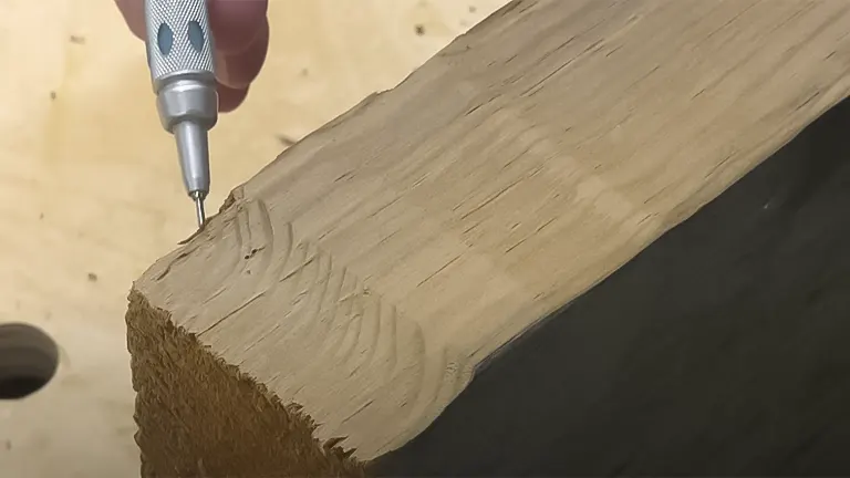 Hand using a marking tool on a planed wooden edge