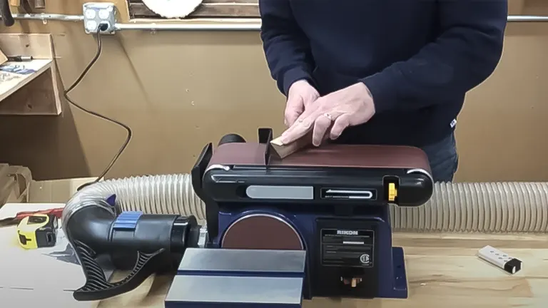 Person using a Rikon 50-112 belt and disc sander in a workshop