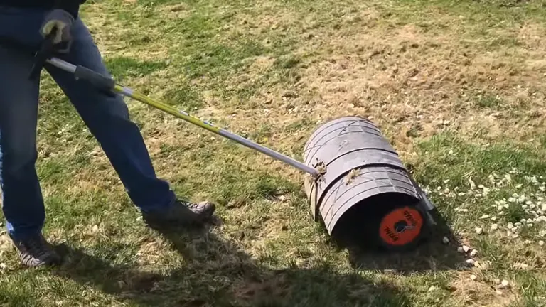 man using the STIHL Rock Sweeper in the grass sweeping the pebbles