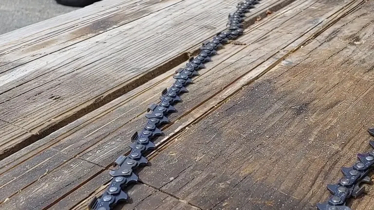 Chainsaw chain laid out on a weathered wooden surface, ready for grinder setup