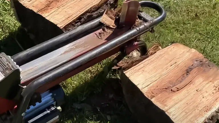 Close-up of Stark USA electric log splitter's hydraulic arm and split log pieces on the ground
