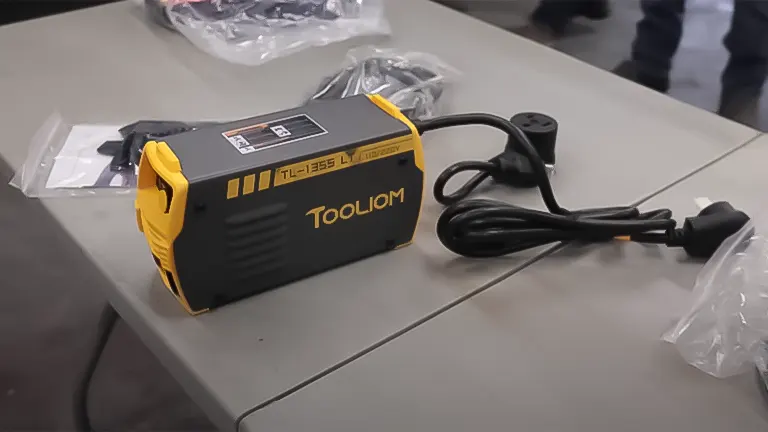 TOOLIOM TL-135S Stick Welder on a table with power cord and accessories in the background