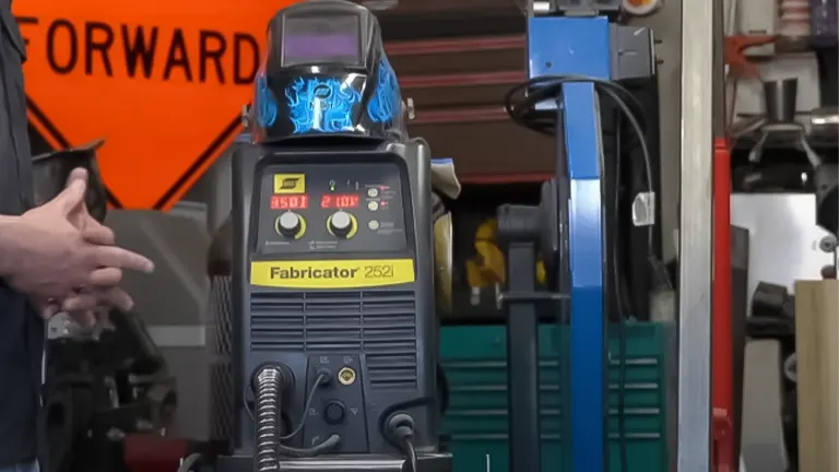 ESAB Fabricator 252i MIG welder with settings display and a welding mask on top