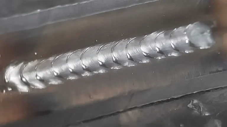 Close-up of a smooth MIG weld bead with a stacked dimes pattern on a metal joint