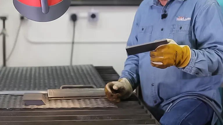 Worker inspecting a metal piece cut by a plasma cutter on a worktable