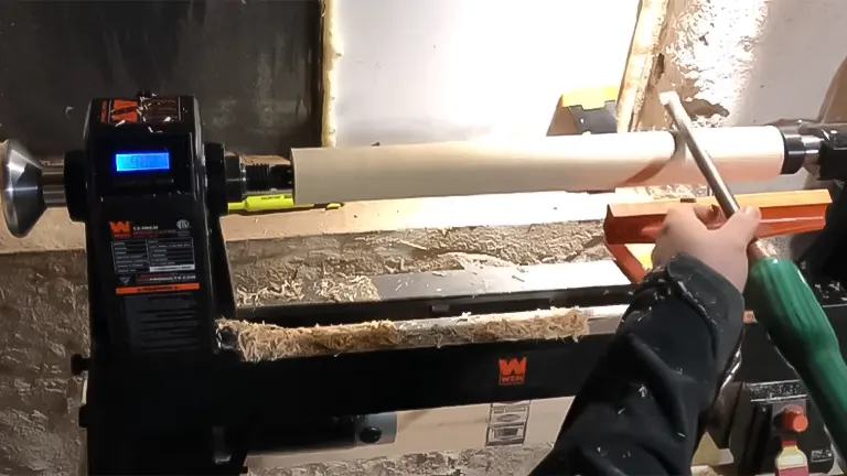 Craftsperson using a WEN 34035 lathe to shape a wooden piece