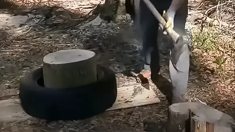 Person splitting wood using the tire trick, with a log placed inside a tire for stability