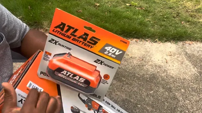 Person holding an ATLAS 40V Lithium Battery package outdoors