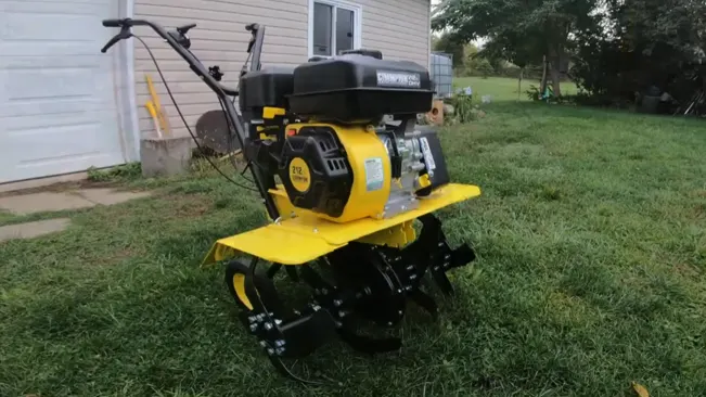well-maintained yellow tiller with black handles, positioned on a green lawn with a white building structure in the background