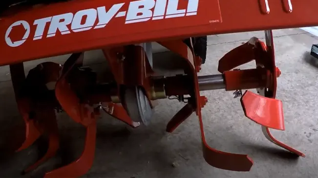 close-up of a red Troy-Bilt tiller with visible mechanical components