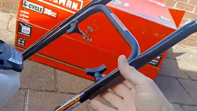 Hand assembling a red Craftsman lawnmower