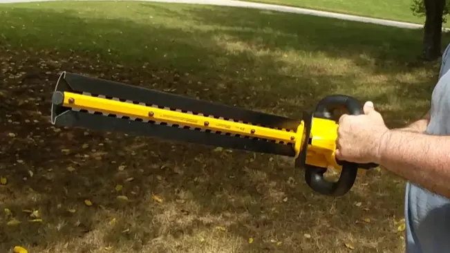 person holding a yellow trimmer outdoors