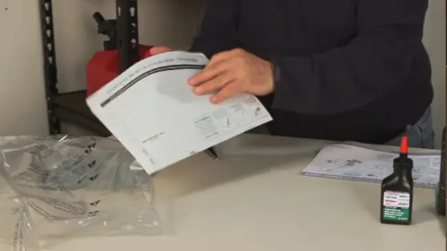 A person reviewing assembly instructions with components and glue on a table.