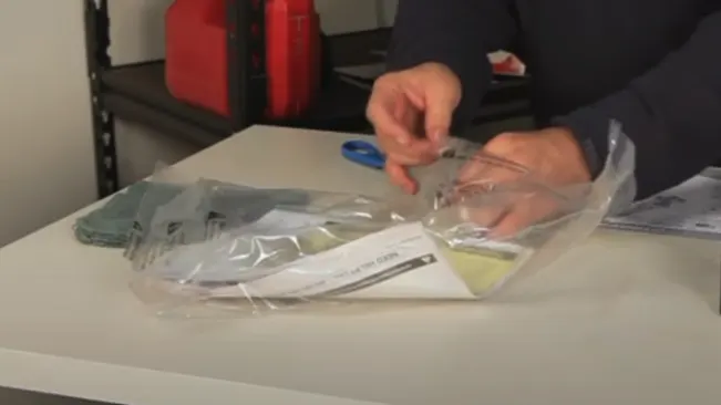 A person is organizing cash and documents inside plastic bags on a table