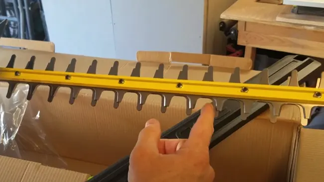 Person measuring a cardboard with a yellow level blade