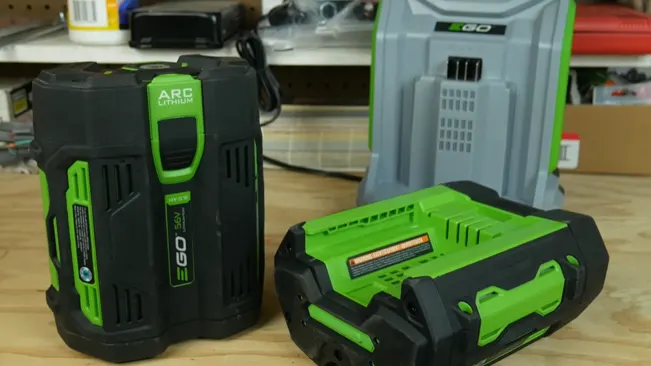 Two rechargeable power tool batteries on a workbench