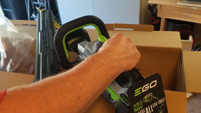 Person unpacking an EGO power tool from a box