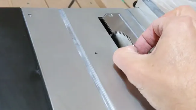 A person adjusting a table saw blade