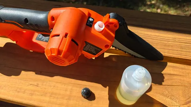 Chainsaw and oil bottle on a wooden table