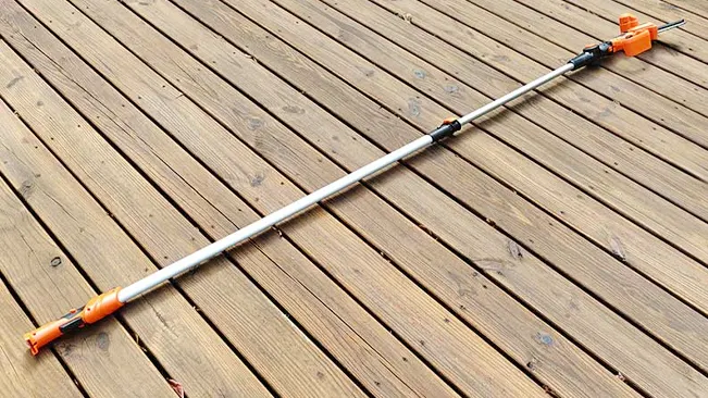 Long metal bar with orange clamps on a wooden deck