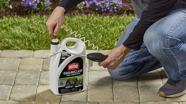 Person kneeling in a garden, using Ortho GroundClear weed killer