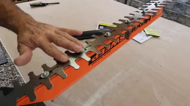Person’s hand adjusting tools on an orange tool organizer on a table