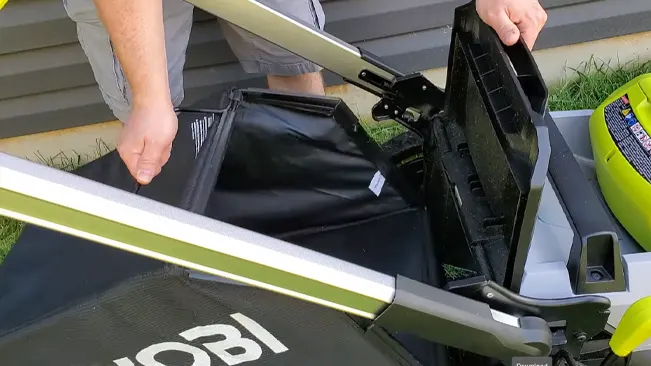 person attaching a collection bag to a Ryobi lawnmower