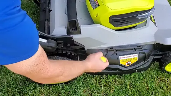 Close-up of hands using lawn mower.