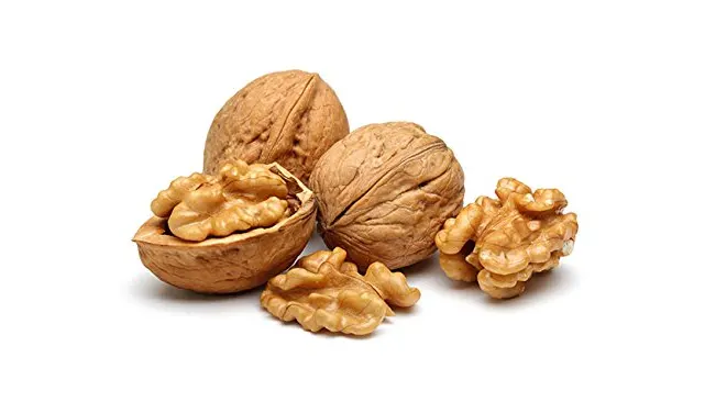 Whole walnuts and walnut halves arranged on a white background, showcasing both shells and nutmeat.