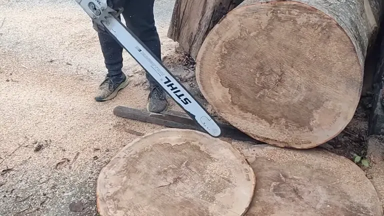 Person using a STIHL MS660 Chainsaw to cut logs