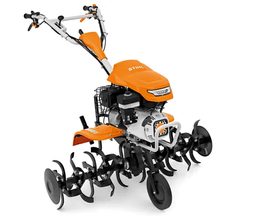 Modern STIHL tiller in orange and black with multiple rotating blades and a front basket attachment