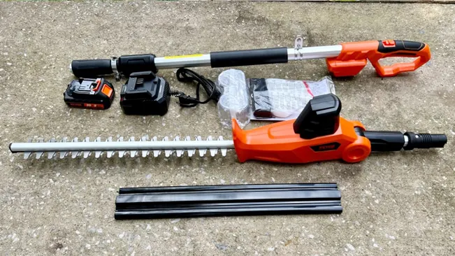 Disassembled cordless hedge trimmer with components on a concrete surface.