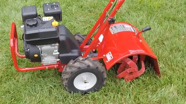 Red garden tiller with a black engine on a green lawn