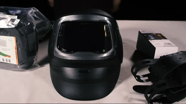 A 3M Speedglas Welding Helmet G5-01 displayed on a table with packaging and accessories in the background.