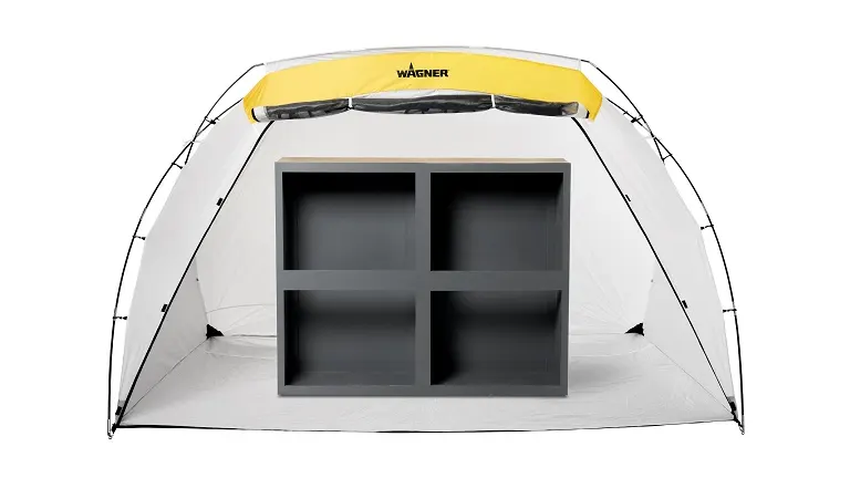 A Wagner Spraytech spray shelter with a yellow and black trim, housing a grey shelving unit inside, set against a white background for a painting project.