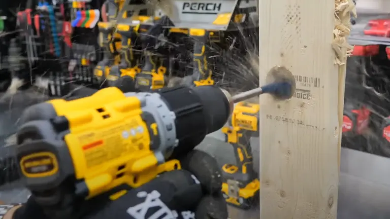 A blurred action shot of a yellow and black DEWALT drill in use, drilling into a wooden beam with sawdust particles flying, indicating the drill's power and activity, set against a background with various tools.