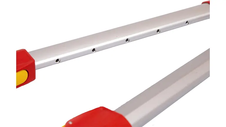 A close-up of the silver telescopic handles of a bypass lopper, featuring red end grips and multiple adjustment holes along the shaft.