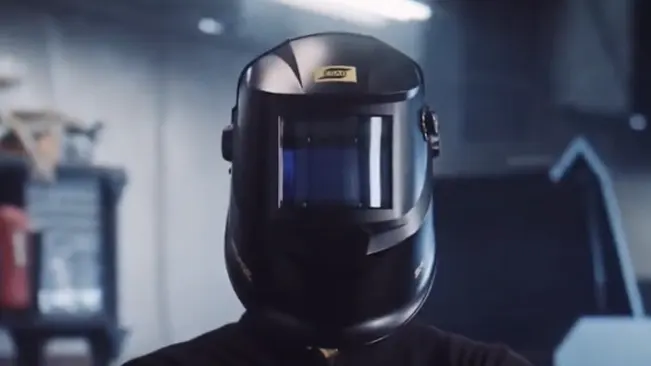 Person wearing an ESAB Savage A40 Air welding helmet in an industrial setting.
